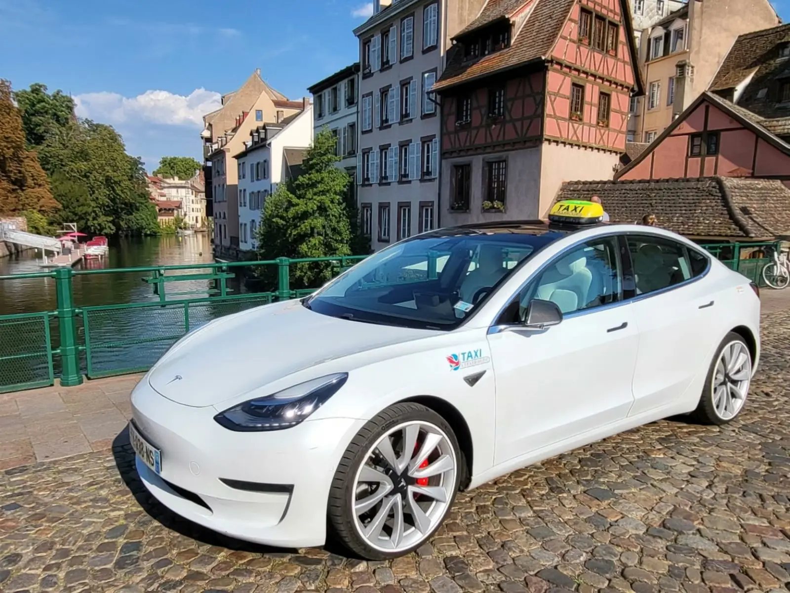 Taxi Tesla blanc stationné au bord de l’Ill, dans le quartier de la Petite France à Strasbourg